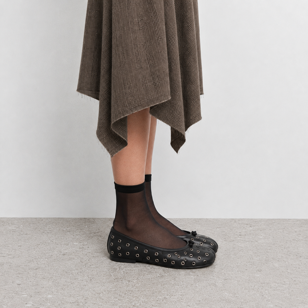 Side profile of a single black leather tabi flat showing the low slim sole