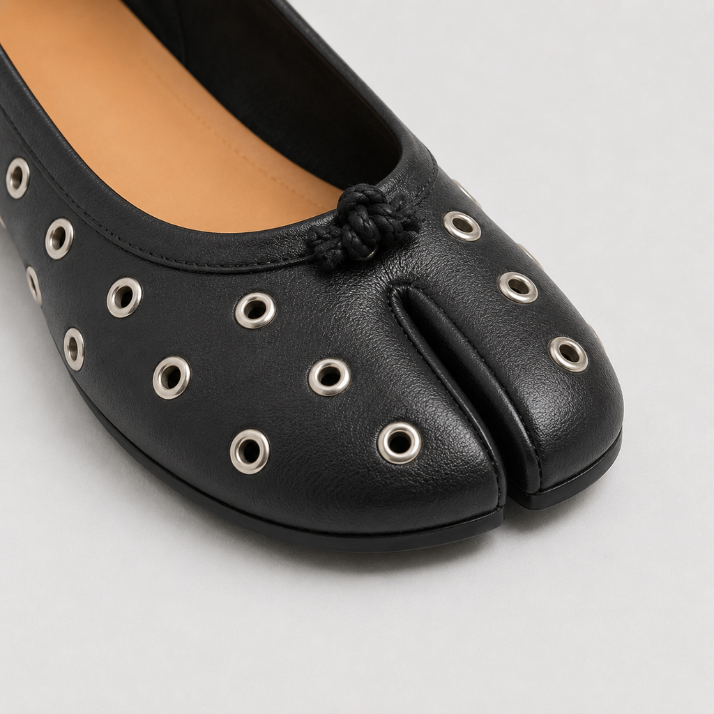 Macro close-up of silver eyelets and the small knot at center front above the split
