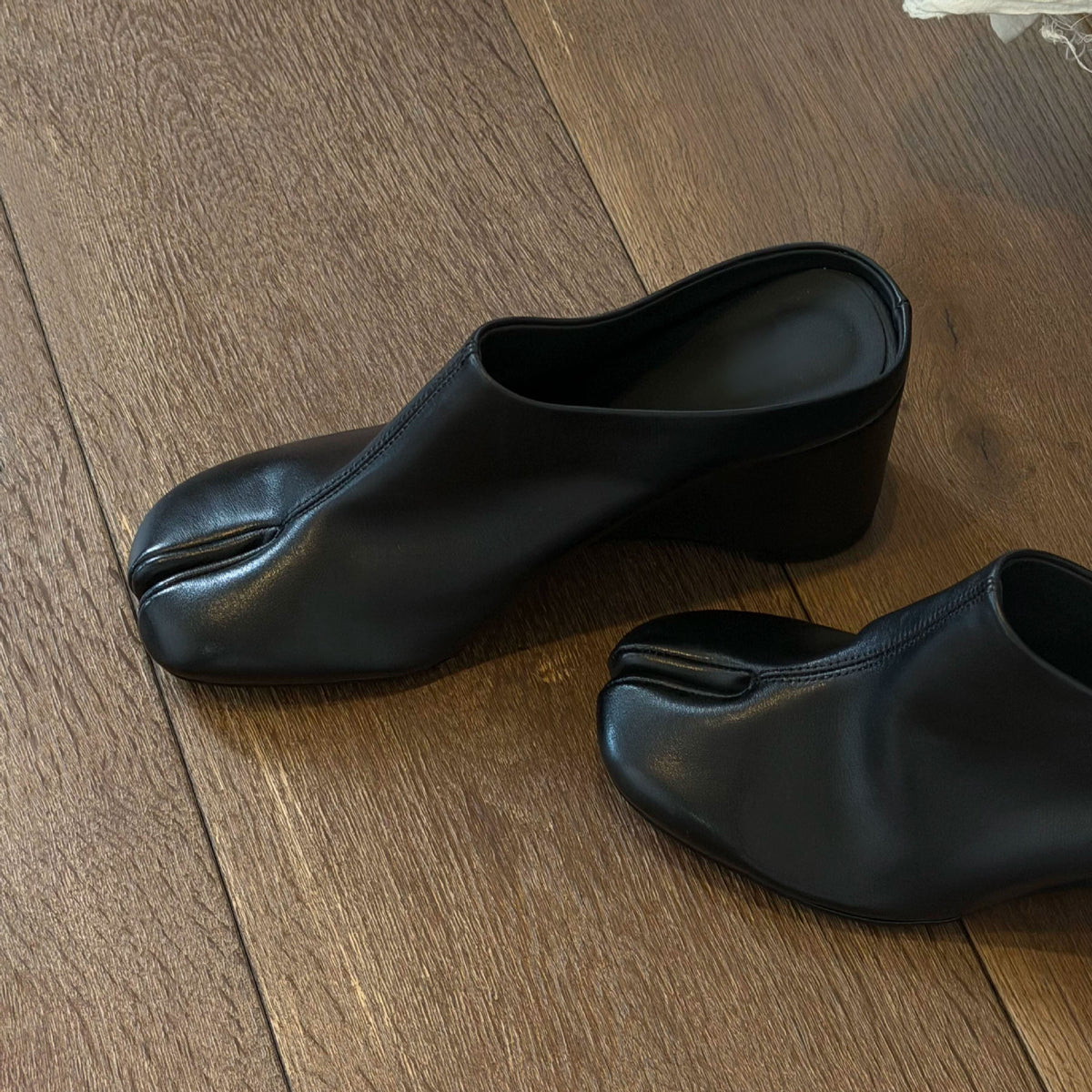 Black tabi wedge slides shown from the side to show the wedge heel height